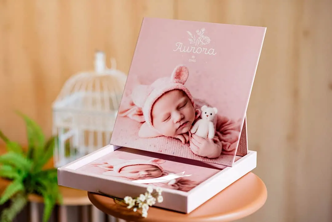 Imagem de álbum de bebê personalizado para fotos de recém-nascido, tema "Aurora", com decoração delicada e estilo infantil.