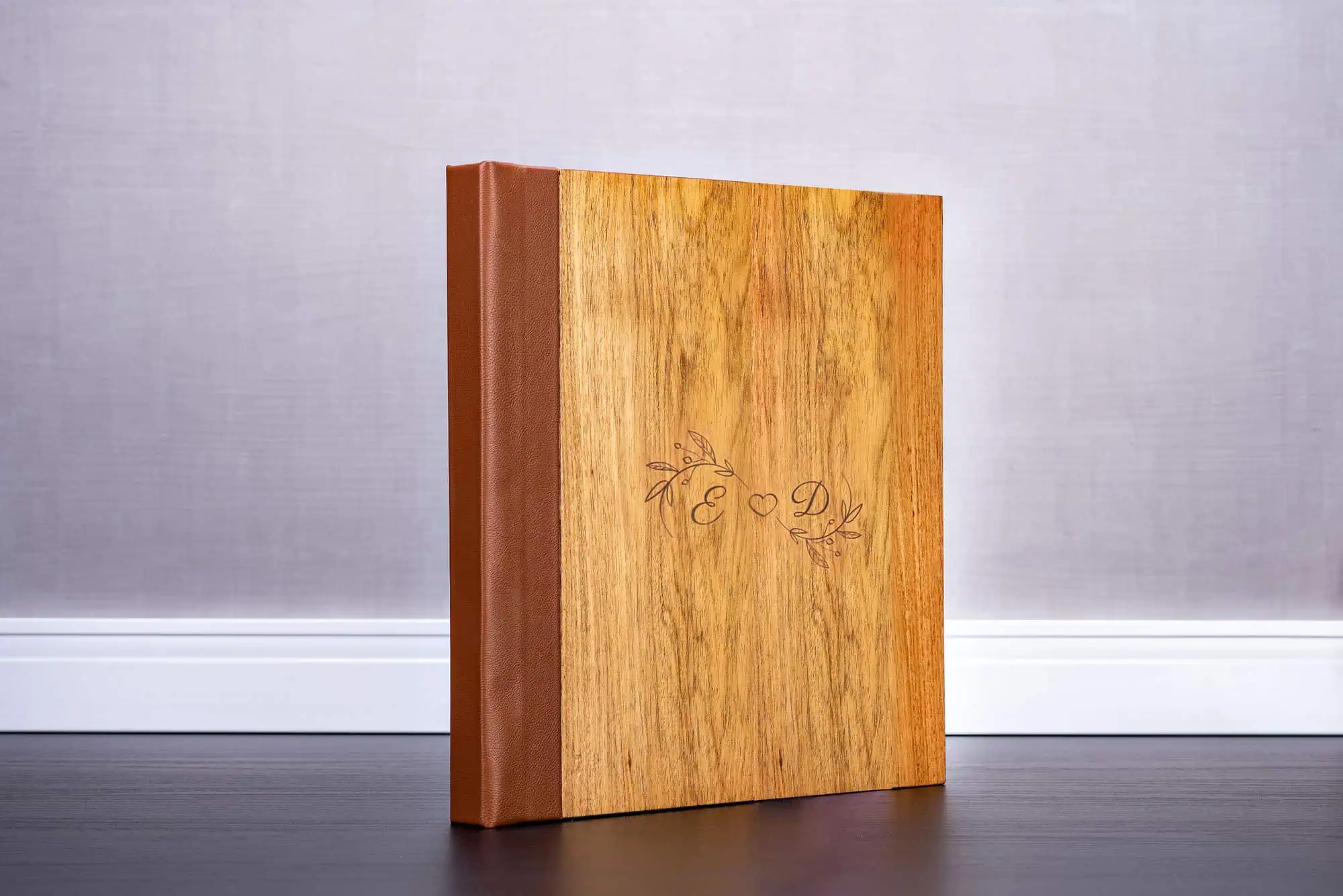 Madeira de álbum de casamento personalizada com gravação de nomes e detalhes decorativos sofisticados.