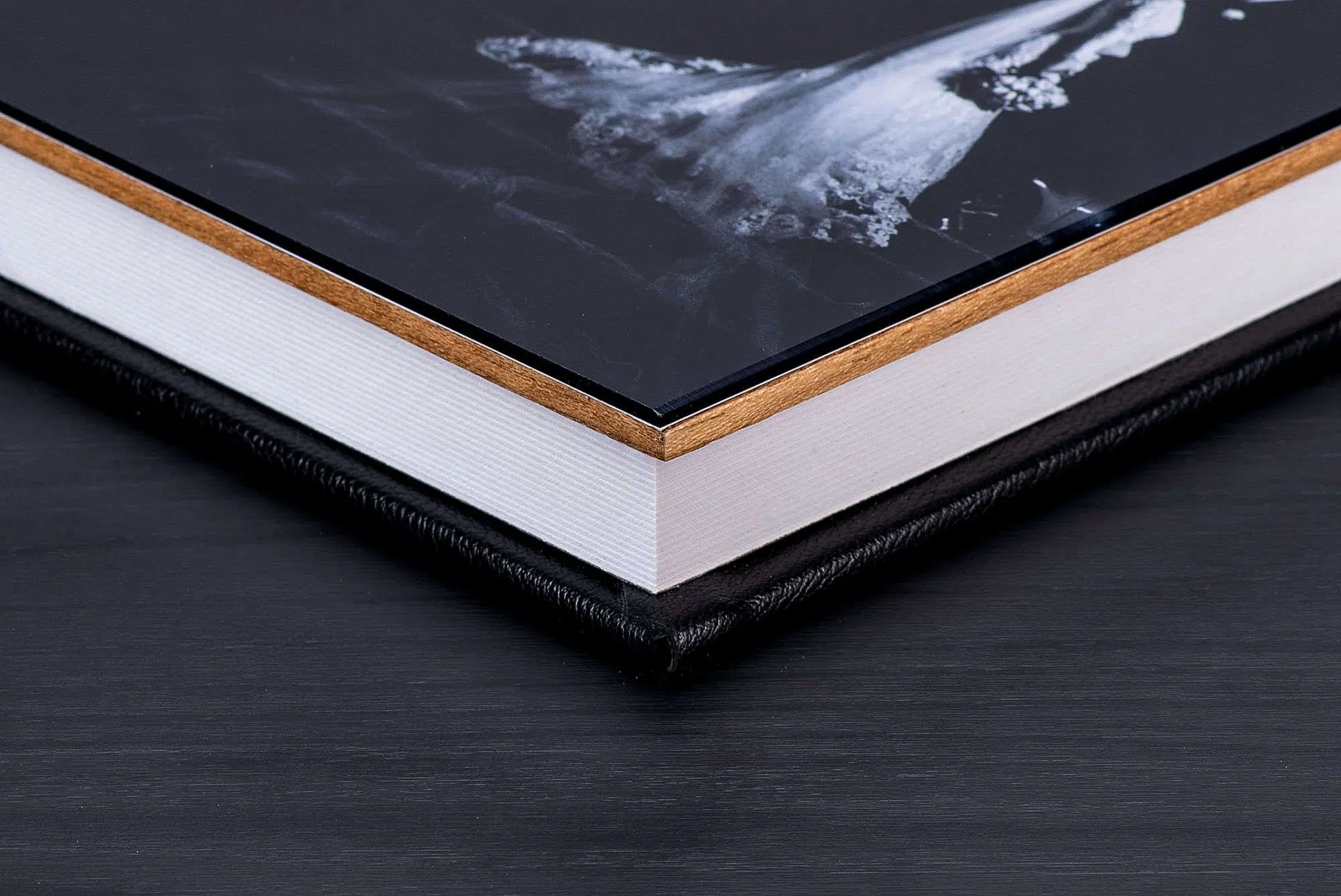 1. Livro de capa dura com acabamento preto, branco e detalhes em madeira para decoração elegante.