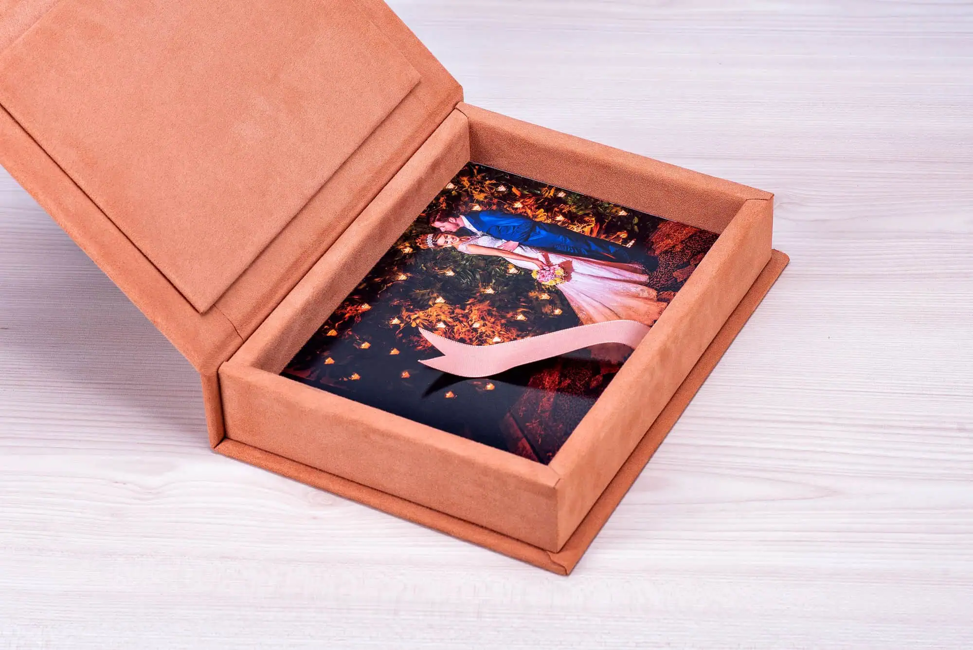 Retrato de um álbum de fotos personalizado com foto de casamento em embalagem de veludo rosa claro.