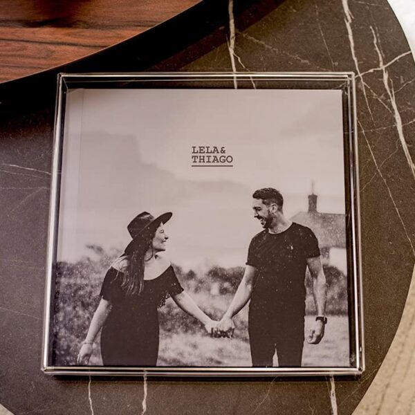 Casal feliz segurando as mãos em foto rústica de casamento personalizada.