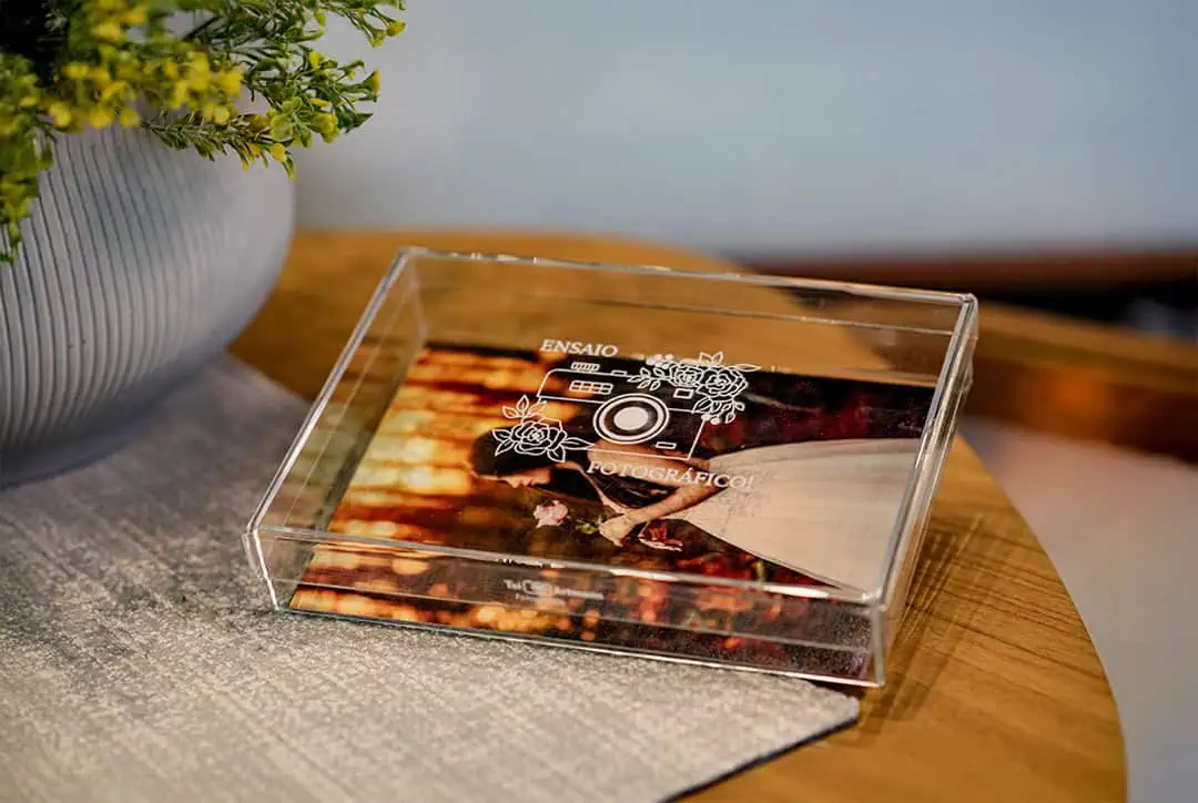 Foto de medalha comemorativa em acrílico personalizada para ensaio fotográfico, com gravação elegante.