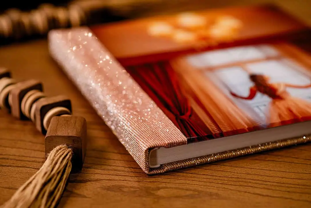 Componente de fechamento de livro com fita dourada e detalhes de velcro brilhante.