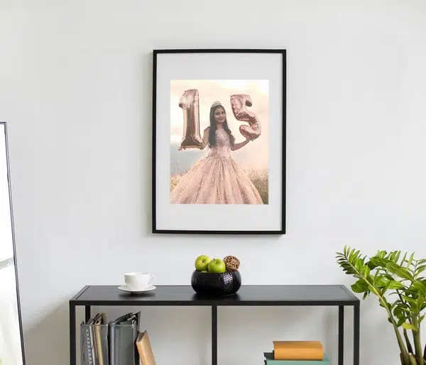1. Fotos decorativas com moldura preta e balões em forma de número 15 e menina vestida de vestido rosa.